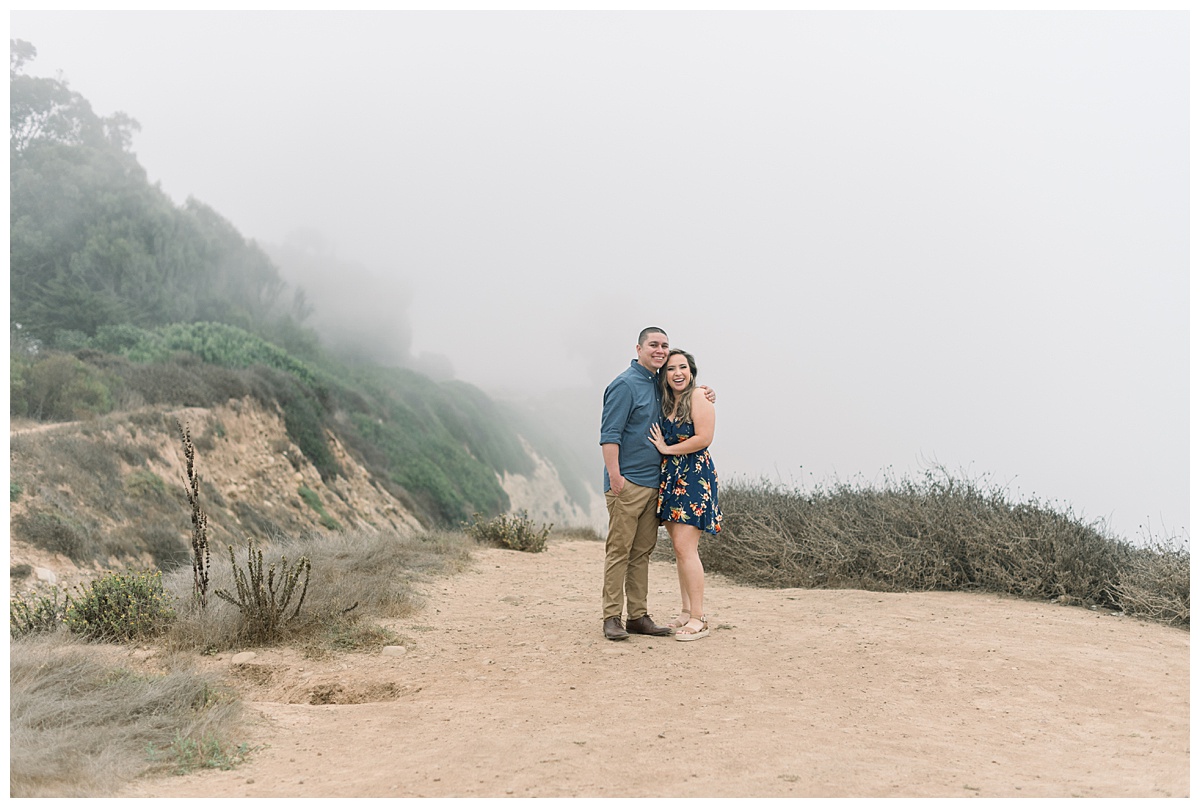 couple smiling and posing on bluffs trail