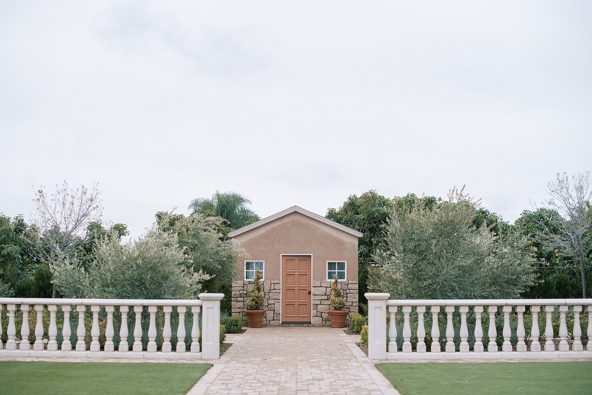 Alternate ceremony view at Tuscan Rose Ranch features stone columns and a view of a getting ready suite