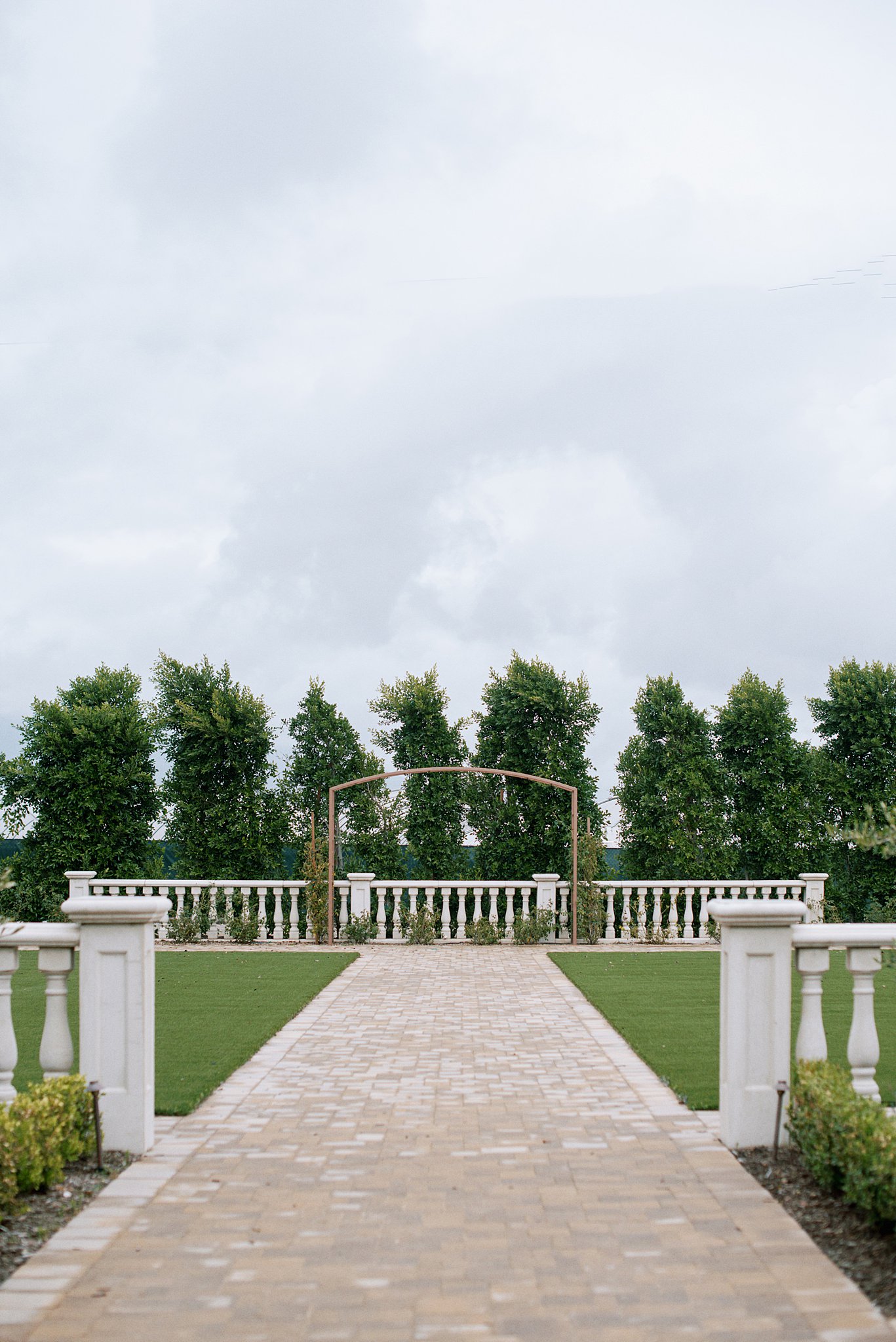 Ceremony site at Tuscan Rose Ranch featuring low columns and an aisle made of stone pavers.